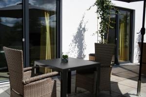 einen schwarzen Tisch und Stühle auf einer Terrasse in der Unterkunft Hotel HeideZeiten in Walsrode