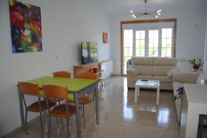 sala de estar con mesa, sillas y sofá en Anduriña 2, en Monforte de Lemos