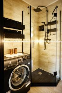 y baño con ducha y lavadora. en Apartament Szczecinek - Spokojna okolica en Szczecinek
