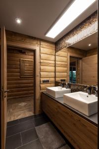 baño con 2 lavabos y espejo grande en Koka Maja en Amatciems