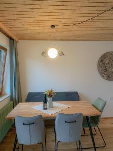 a dining room table with two chairs and a light fixture at Landhaus Gappmaier in Zell am See