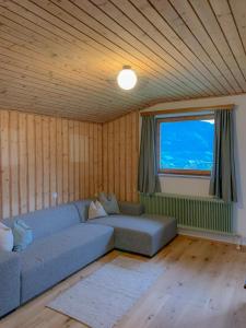 a living room with a couch and a large window at Landhaus Gappmaier in Zell am See