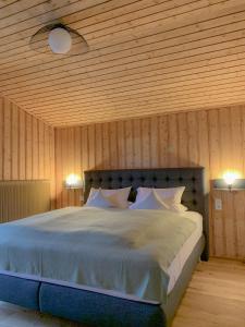 Schlafzimmer mit einem großen Bett und Holzwänden in der Unterkunft Landhaus Gappmaier in Zell am See