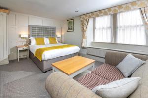 une chambre d'hôtel avec un lit et un canapé dans l'établissement The Woolly Sheep Inn, à Skipton