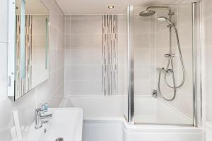 La salle de bains blanche est pourvue d'une douche, d'une baignoire et d'un lavabo. dans l'établissement The Woolly Sheep Inn, à Skipton 57 autres photos