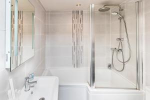 ein weißes Badezimmer mit einer Dusche, einer Badewanne und einem Waschbecken in der Unterkunft The Woolly Sheep Inn in Skipton
