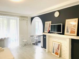 a living room with a fireplace and a clock on the wall at Premium Rent in Kiev Centre - Kiev in Kyiv