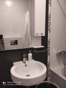 ein Badezimmer mit einem weißen Waschbecken und einem Spiegel in der Unterkunft Apartment Memories in Banja Luka