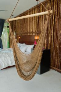 een hangmat in een kamer met een bed bij Saak Luúm Ruta Puuc in Sacalum