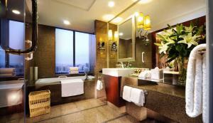 Crowne Plaza Beijing Zhongguancun, an IHG Hotel في بكين: حمام كبير مع حوض ومغسلة