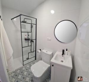 a bathroom with a toilet and a sink and a mirror at VILLA PITATO Nuevo, cerca de la Playa, Parking en la puerta del alojamiento in Cala del Moral