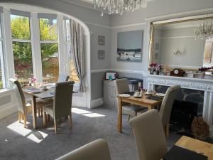 a dining room with a table and chairs and a fireplace at Bentley Lodge in Torquay
