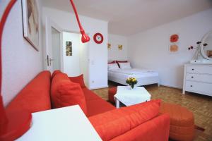 uma sala de estar com um sofá vermelho e uma cama em Tonis Apartment Erkrath em Erkrath