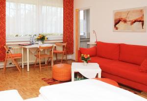 uma sala de estar com um sofá vermelho e uma mesa em Tonis Apartment Erkrath em Erkrath