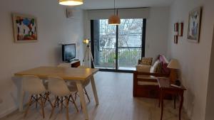 a living room with a table and chairs and a television at Delta Apart in Tigre