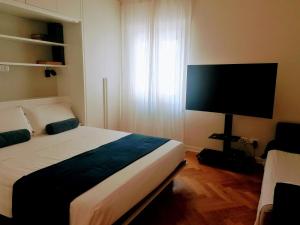 a bedroom with a bed and a flat screen tv at Letizia Apartment in Crotone