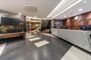 an office lobby with a reception desk and a staircase at Hotel Laghetto Bento in Bento Gonçalves