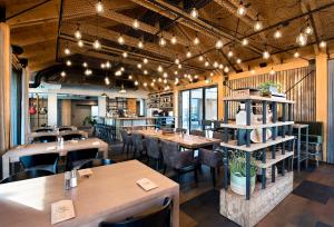 a restaurant with wooden tables and chairs and lights at Alpine House, NATUR RESORT in Kežmarok