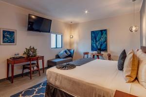 メリダにあるYoussef Exceptionnel Meridaの大きなベッドとデスクが備わるホテルルームです。