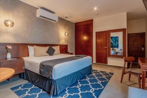 a hotel room with a bed and a table and chairs at Youssef Exceptionnel Merida in M&eacute;rida