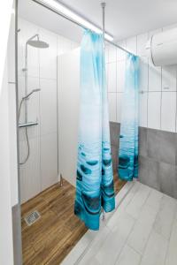 y baño con ducha y cortinas azules. en KempingZator Namioty en Zator