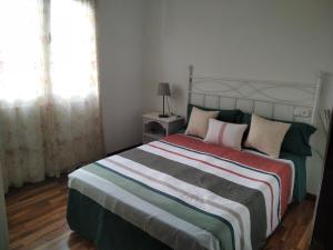 Un dormitorio con una cama grande y una ventana en Casa Bayona, en Monte