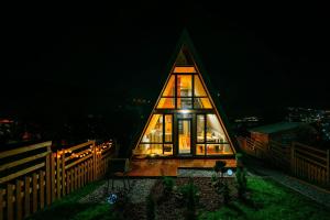 une petite maison éclairée la nuit dans l'établissement Krest relaxing heights, à Vatra Dornei