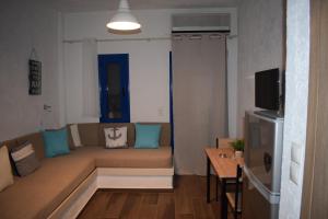 a living room with a couch and a table at Katovigli Seaview Apartment in Makry Gialos