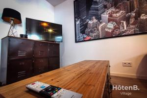 a living room with a tv and a wooden table at CLIM Jolie maison de 60 m2 avec jardin in Limoges