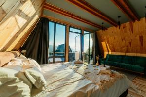 a bedroom with a large bed and a green couch at Krest relaxing heights in Vatra Dornei