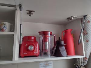 uma prateleira de cozinha com um liquidificador e um aparelho vermelho em Home Office Curitiba/vaga de estacionamento grátis em Curitiba