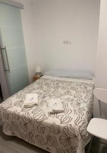 1 dormitorio con 1 cama con 2 toallas en Pensión LF No Fumadores - Sin Ascensor en Zaragoza