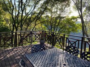 una mesa y sillas en un balcón con vistas en Cabbage Tree Cottage en Hilton