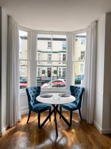 a table and two chairs in a room with a window at One Abbey Court in Whitby