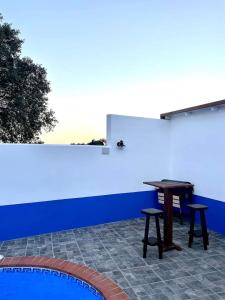 El Cristo del Espíritu Santo的住宿－Dos VILLAS ENTRE CIERVOS Y CERVANTES，一张桌子和两张靠着蓝色墙壁的凳子