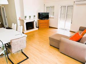 ein Wohnzimmer mit einem Sofa und einem TV in der Unterkunft Flat 3 Bedrooms Albufeira in Albufeira