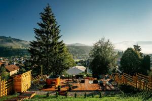 a picnic table with an umbrella and a tree at Krest relaxing heights in Vatra Dornei