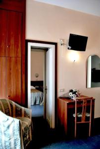 Cette chambre comprend un lit, une table et un miroir. dans l'établissement Hotel Acerboli, à Rimini