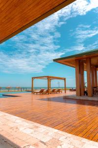 una terraza de madera con bancos y vistas al océano. en Karibao Resort Town, en Playas