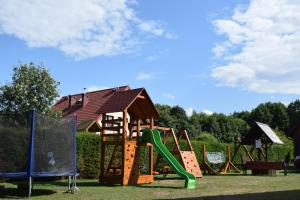 a playground with a slide and a play structure at Dom Muszelka in Lubiatowo