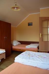 a bedroom with two beds and a window at Dom Muszelka in Lubiatowo