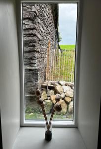 a vase with flowers in front of a window at Two Bedroom, Newly Renovated, Garden Apartment in Gärsnäs, Österlen in Gärsnäs