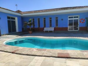 una piscina frente a una casa azul en Casa La Caldera, en Firgas