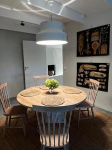 a dining room table with chairs and a vase of flowers on it at Two Bedroom, Newly Renovated, Garden Apartment in Gärsnäs, Österlen in Gärsnäs