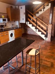 una cocina con mesa, fregadero y escaleras en CASA RURAL LA CIJA, en Maello