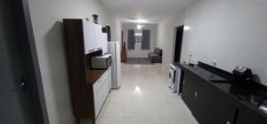 a kitchen with white appliances and a long hallway at Casa Pôr do Sol in Fundão