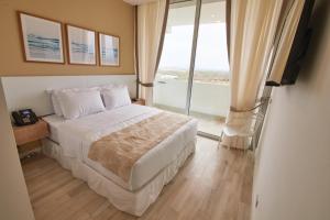 a bedroom with a bed and a large window at Karibao Resort Town in Playas