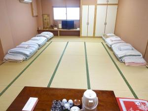 um quarto com uma fila de camas no chão em Imazato Ryokan - Vacation STAY 02551v em Osaka