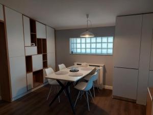 - une cuisine avec une table et des chaises blanches dans l'établissement Lovely Apartment Ioana, à Tîrgu Neamţ