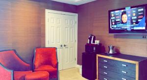 a living room with a red chair and a tv at Rocky River Inn in New Milford